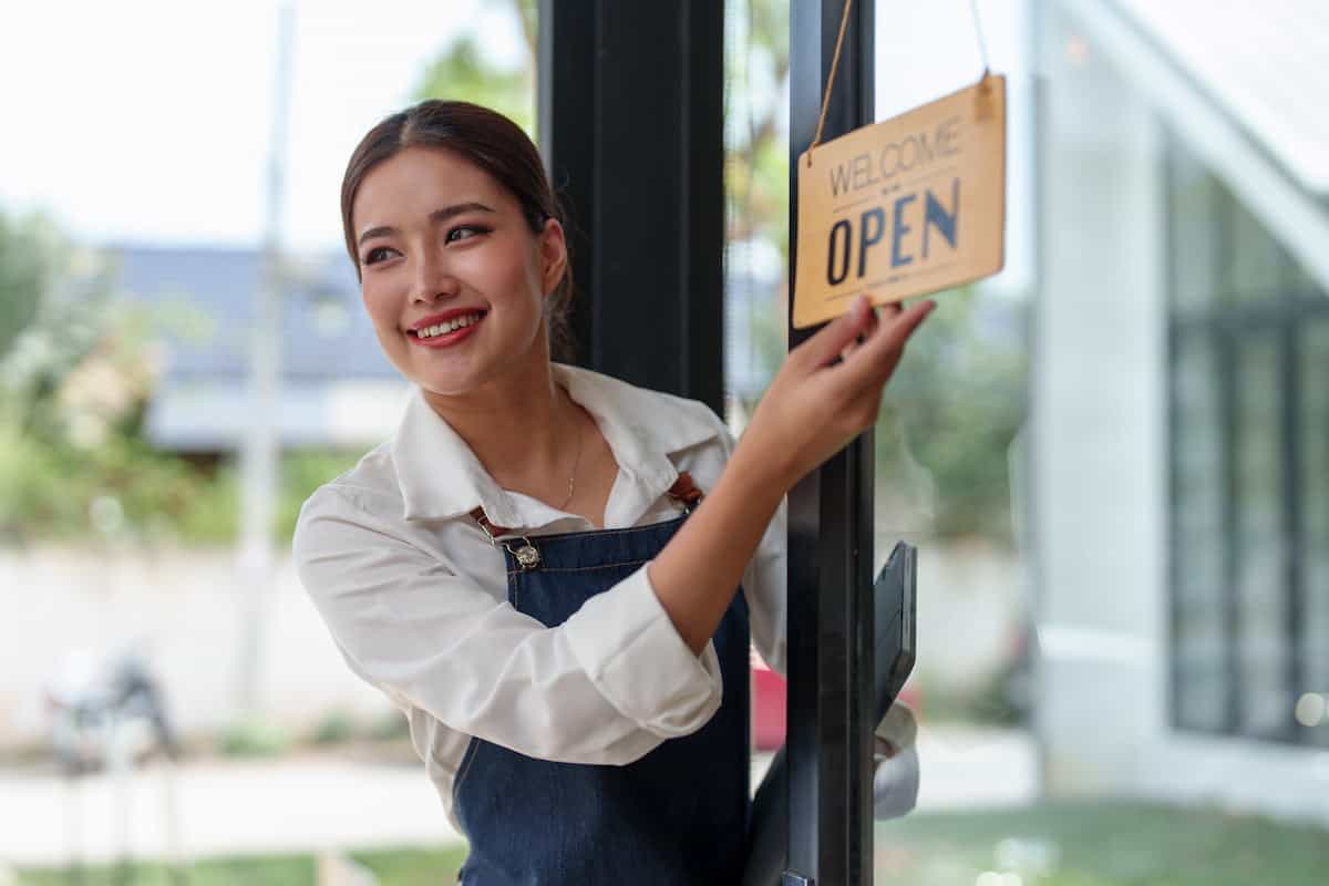 Smiling business owner opening up her store in the morning